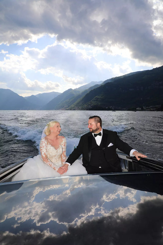 Bride and groom exchanging vows aboard a private boat on Lake Como with mountain views.